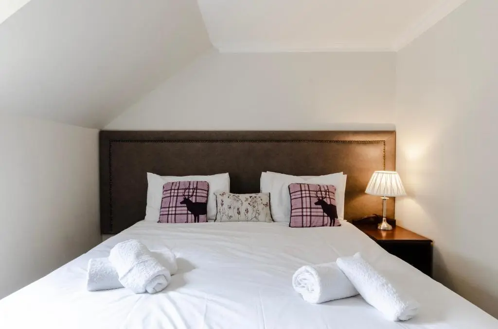 a bedroom with a large white bed with two pillows at Sweeney Aviemore Two in Aviemore