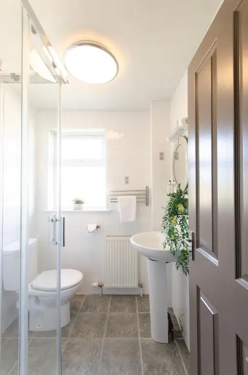 a bathroom with a toilet and a sink and a shower at Sweeney Aviemore Two in Aviemore