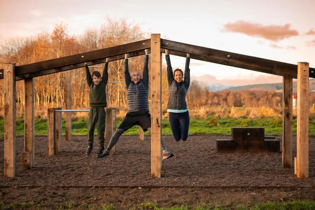 a group of three people on a swing set at Swiss Chalet Balnagown Castle in Kildary
