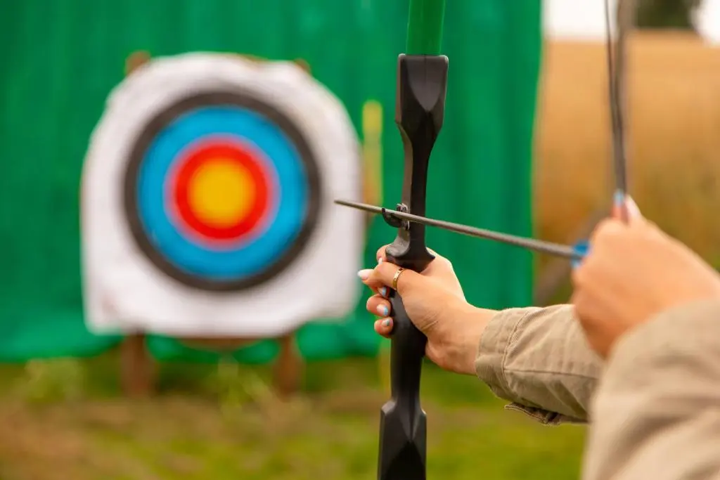 a person holding a bow and arrow in front of a target at Swiss Chalet Balnagown Castle in Kildary