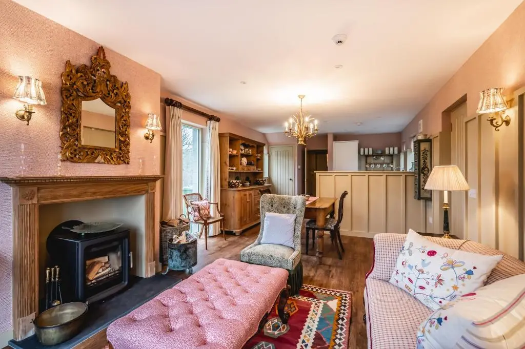 a living room with a couch and a fireplace at Swiss Chalet Balnagown Castle in Kildary