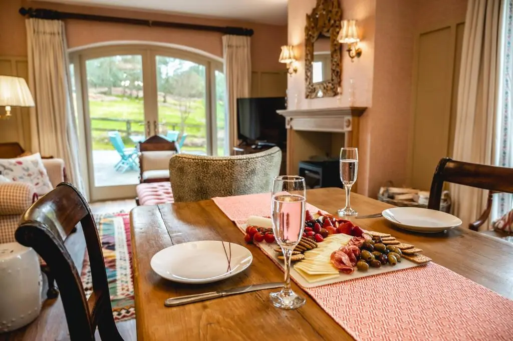 a wooden table with wine glasses and food on it at Swiss Chalet Balnagown Castle in Kildary