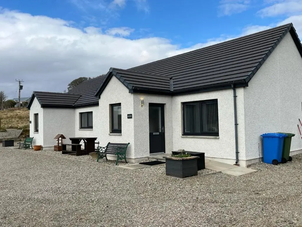 a white house with a black roof at Highland Holiday Lets Lairg in Lairg