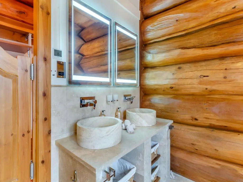 a bathroom with two sinks and a wooden wall at Molalatau Lodge in Lairg