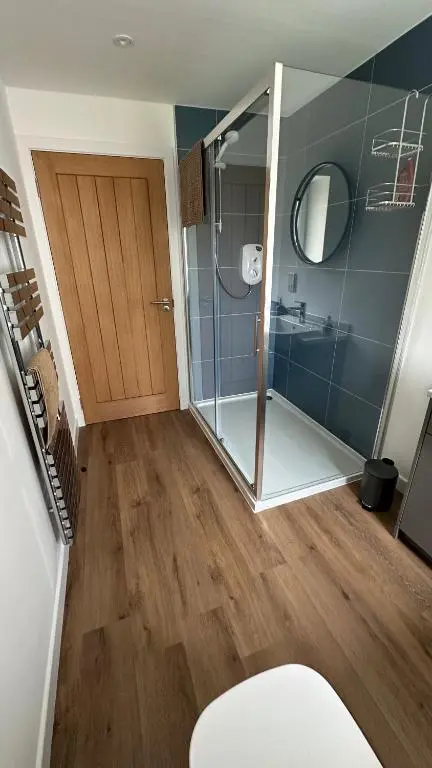 a bathroom with a shower and a glass door at Drumfin Cottage in Elgin