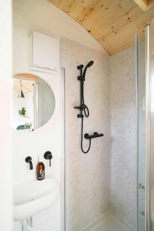 a bathroom with a shower and a sink at Willow's Nordic Shepherds Hut in Ballater