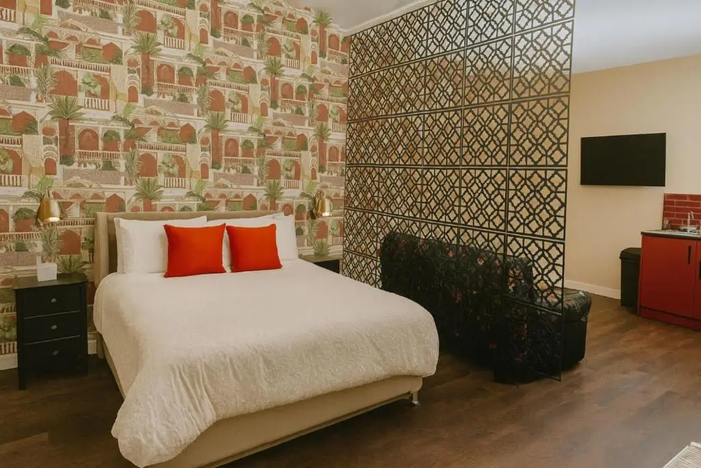 a bedroom with a bed with two red pillows at Inbhir Nis City Apartment in Inverness