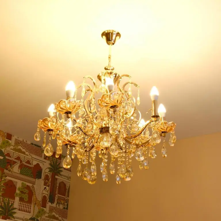 a gold chandelier hanging from a ceiling at Inbhir Nis City Apartment in Inverness
