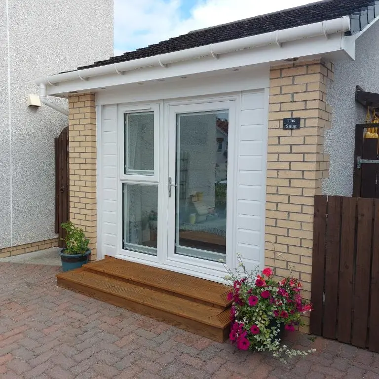 a house with a wooden deck with a window at The Snug - Cosy Retreat for Two in Inverness