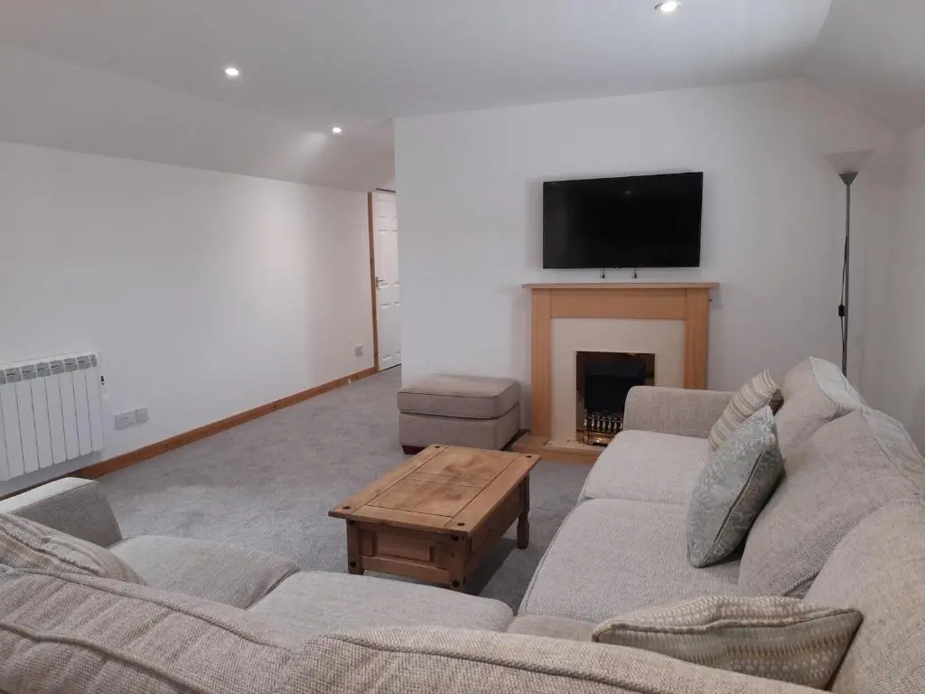a living room with two couches and a fireplace at Culbokie Inn on the NC500 in Culbokie