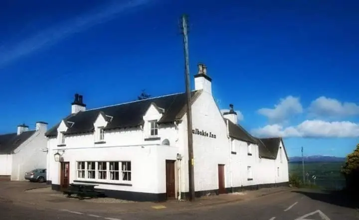 a white building with a black roof at Culbokie Inn on the NC500 in Culbokie