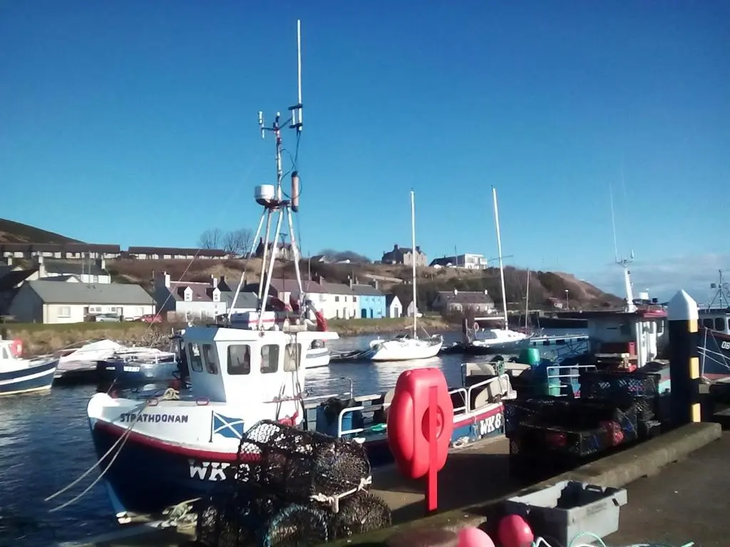a group of boats docked in a harbor at Selkie House Song of the Sea in Helmsdale