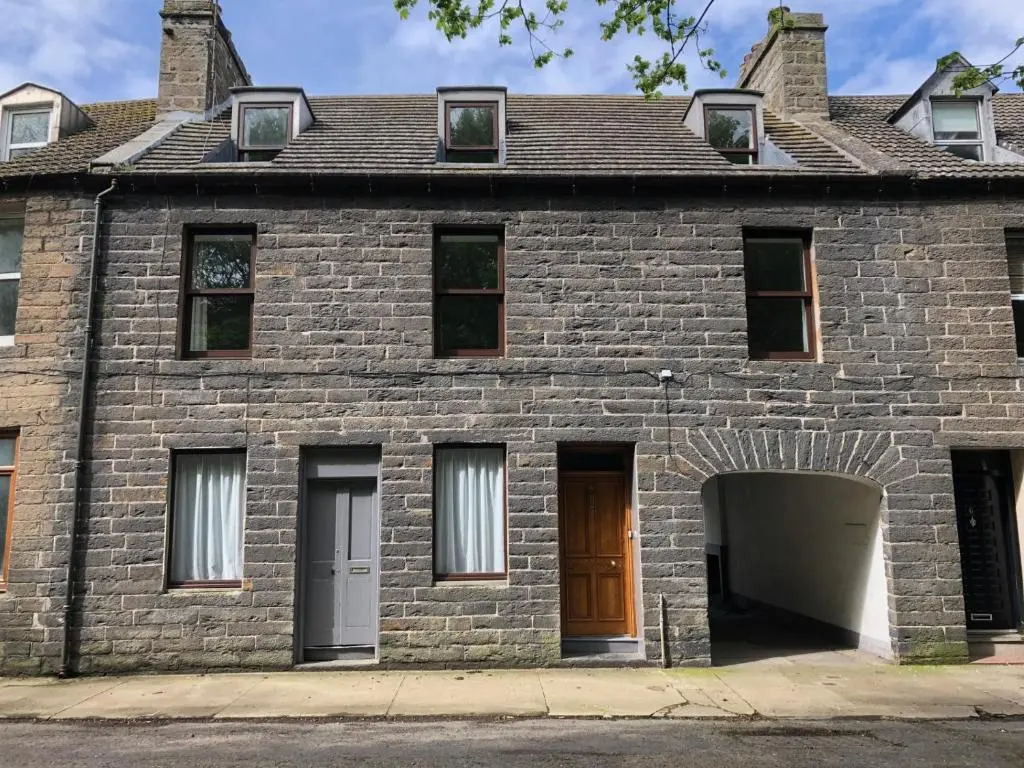 an old brick house with a brown door at Spacious Harbour House in Wick