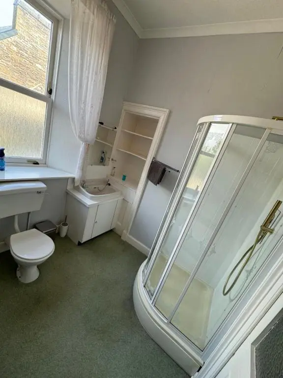 a bathroom with a shower and a toilet and a sink at Spacious Harbour House in Wick