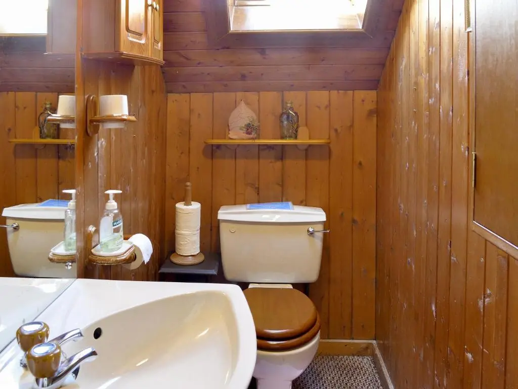 a wooden bathroom with a toilet and a sink at Dalvanie Mill - S4241 in Tulchan