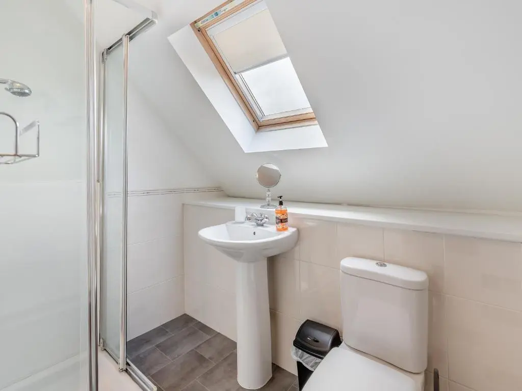 a bathroom with a sink and a toilet and a skylight at Croftside House - S4401 in Inverdruie