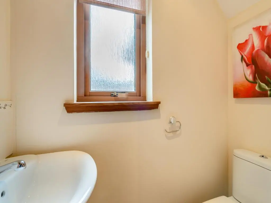 a bathroom with a toilet and a sink and a window at Clunnie Mor - S4615 in Aviemore