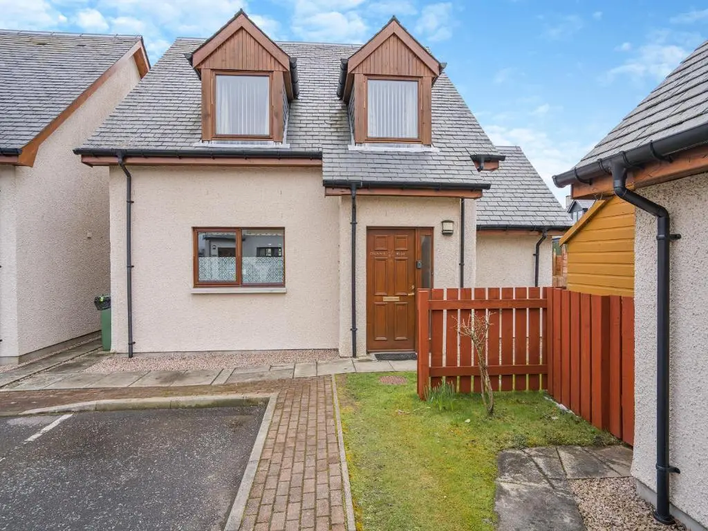 a house with a wooden fence in front of it at Clunnie Mor - S4615 in Aviemore