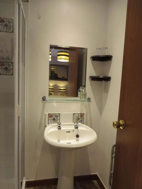 a bathroom with a white sink and a mirror at Eriskay Guest House and Aviemore Glamping in Aviemore