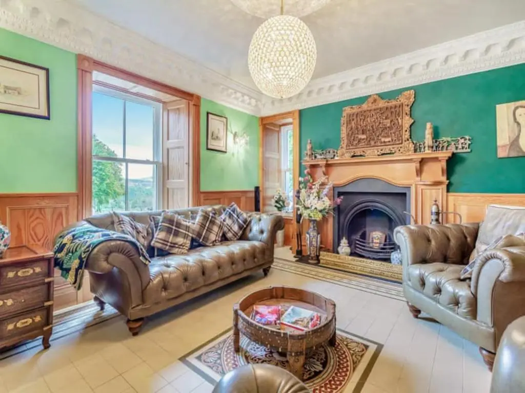 a living room with a couch and a fireplace at The Doune, Luxury Traditional Country House with hot tub in Inverness
