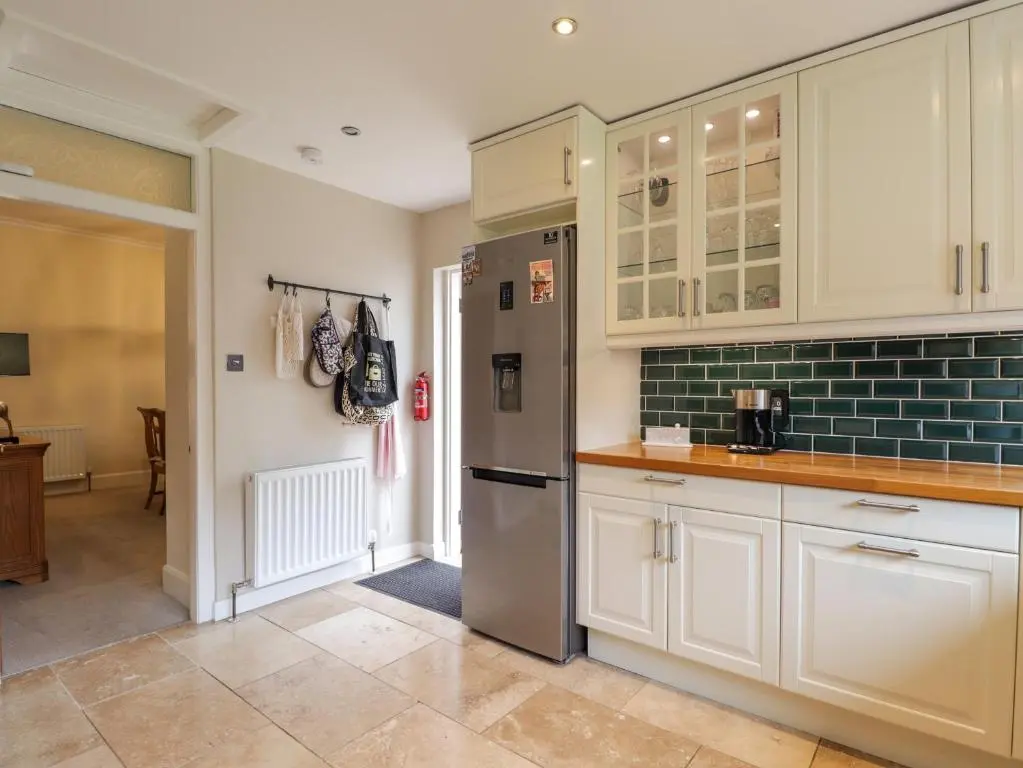 a kitchen with white cabinets and a stainless steel refrigerator at Garry Isle in Inverness