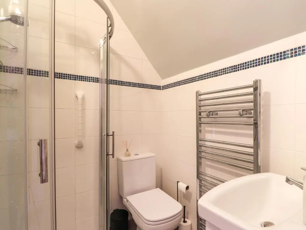 a bathroom with a toilet and a shower and a sink at Garry Isle in Inverness