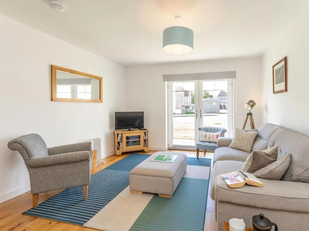 a living room with a couch and a tv at Apartment The Muir by Interhome in Aviemore