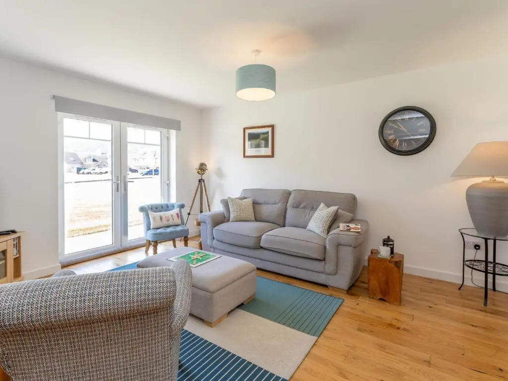 a living room with a couch and a chair at Apartment The Muir by Interhome in Aviemore