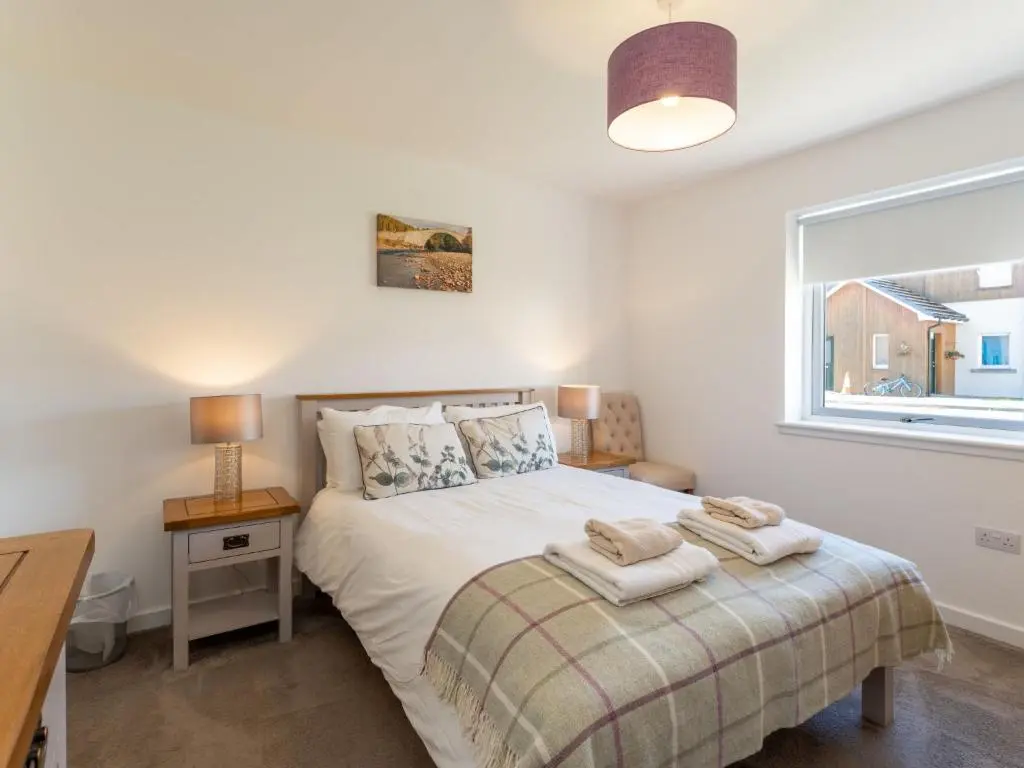 a bedroom with a bed with towels on it at Apartment The Muir by Interhome in Aviemore