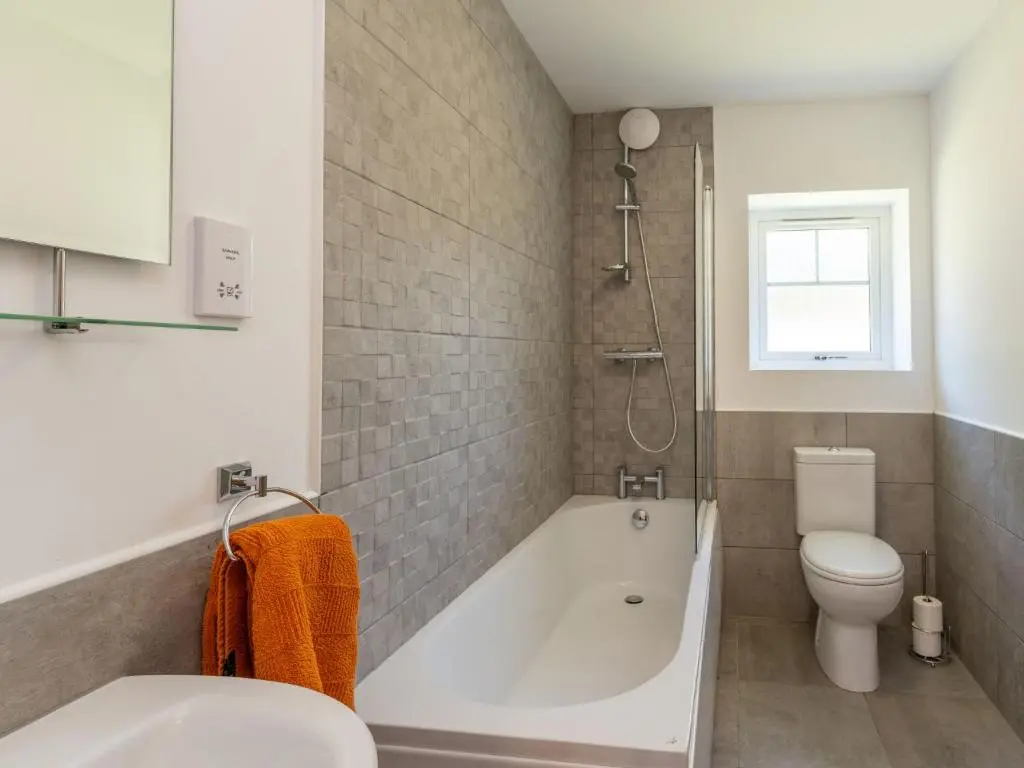 a bathroom with a white tub and a toilet at Apartment The Muir by Interhome in Aviemore