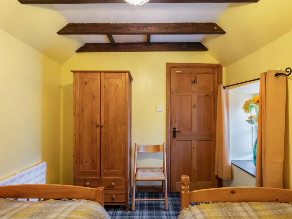 a bedroom with two beds and a wooden ceiling at Holiday Home Sunflower Cottage by Interhome in Marnoch