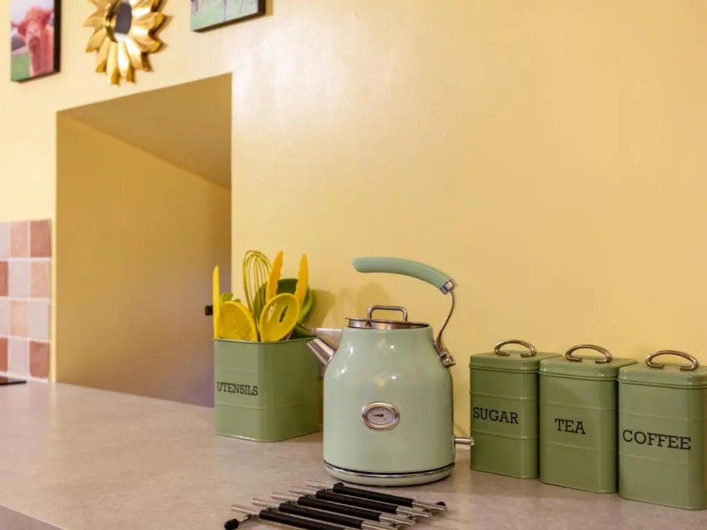 a kitchen counter with a tea kettle and two canisters at Holiday Home Sunflower Cottage by Interhome in Marnoch