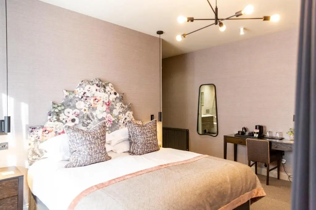 a bedroom with a bed and a desk and a table at Hotel 1881 of Speyside in Archiestown