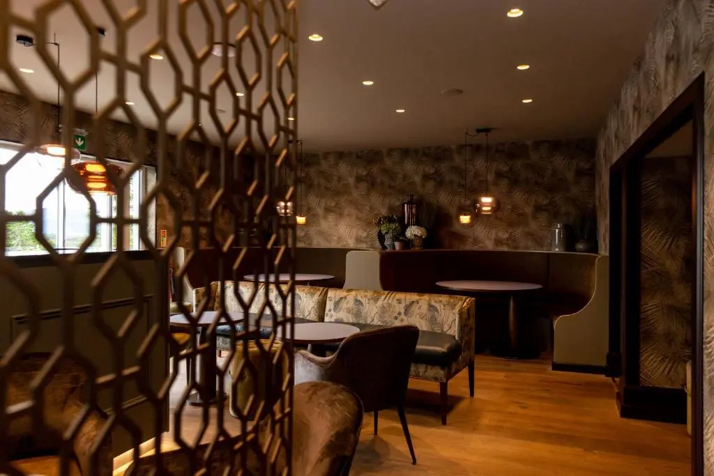 a restaurant with tables and chairs and a bar at Hotel 1881 of Speyside in Archiestown