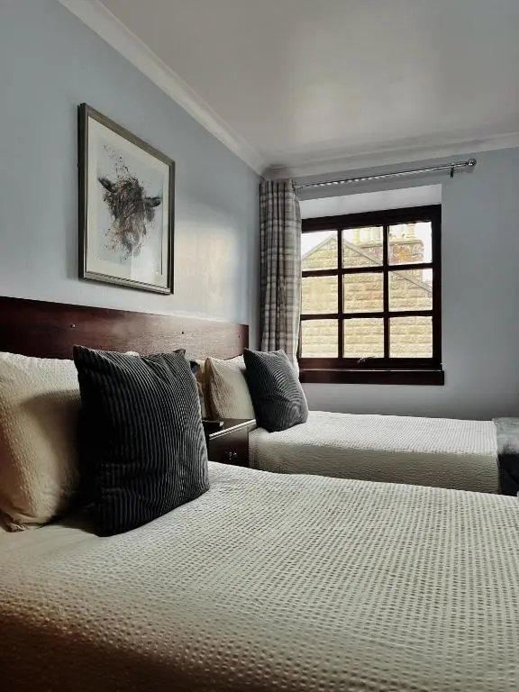 a hotel room with two beds and a window at The Stag Hotel in Banchory