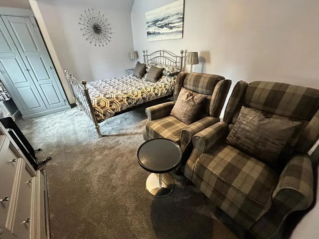 a living room with two couches and a bed at St Duthus Hotel in Tain