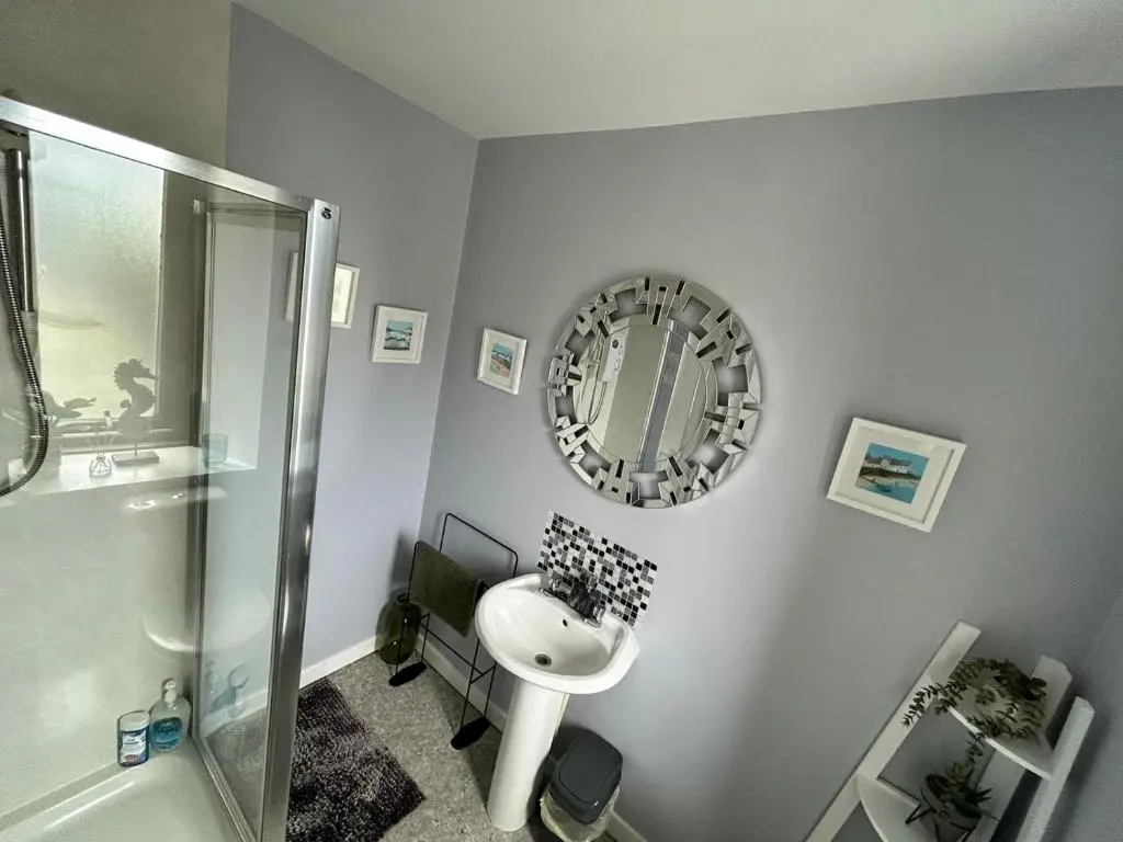 a bathroom with a sink and a shower and a mirror at St Duthus Hotel in Tain