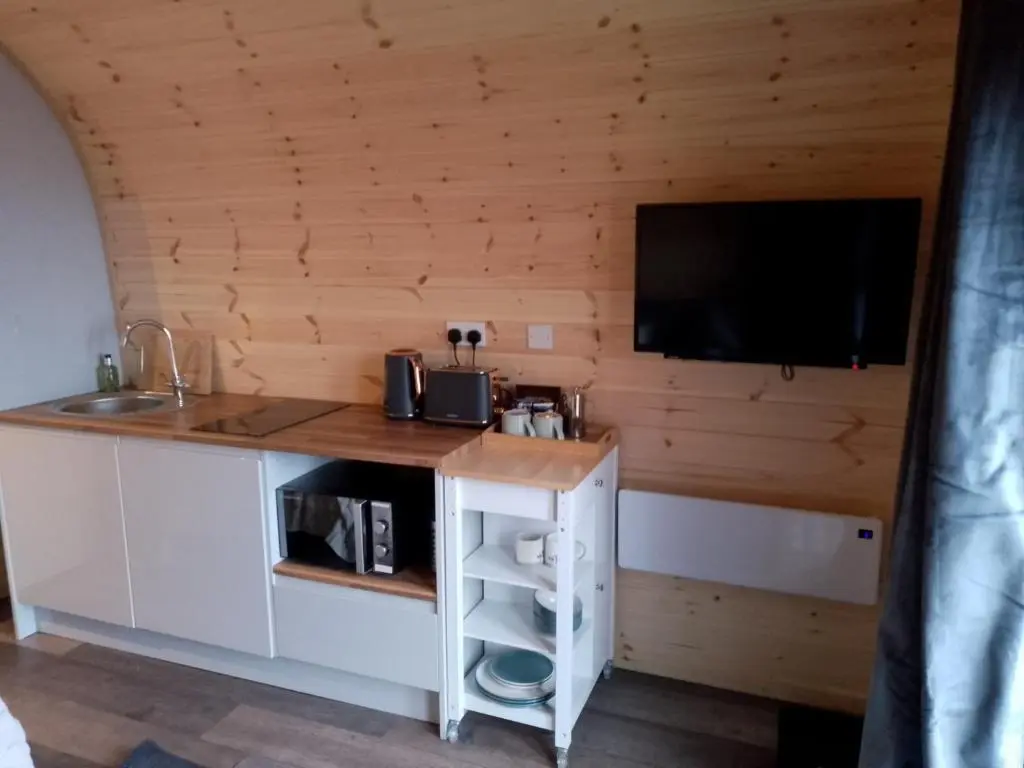 a kitchen with a sink and a tv on a wall at Turadh 'a break in the clouds' in Dunbeath