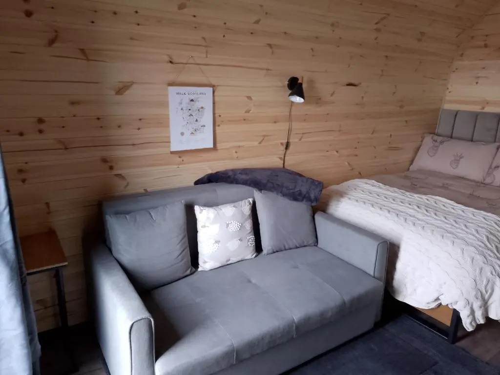 a living room with a couch and a bed at Turadh 'a break in the clouds' in Dunbeath
