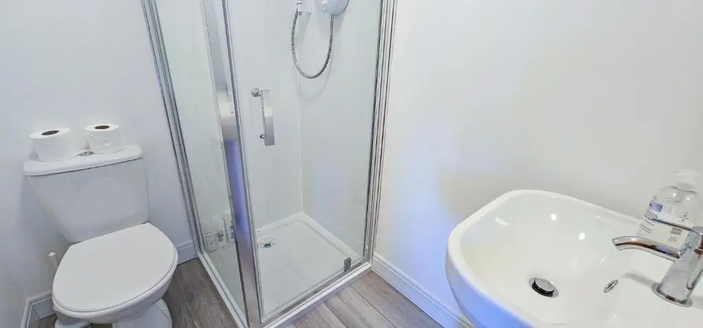 a bathroom with a shower and a toilet and a sink at Melrose Villa 11 Bedroom House in Inverness