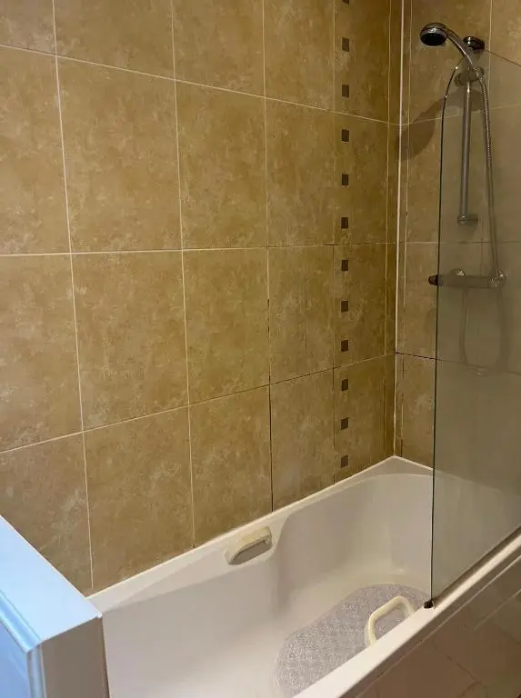 a bathroom with a tub with a glass shower at MacIver City Apartment Academy Street in Inverness