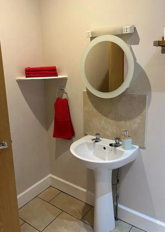 a bathroom with a white sink and a mirror at MacIver City Apartment Academy Street in Inverness
