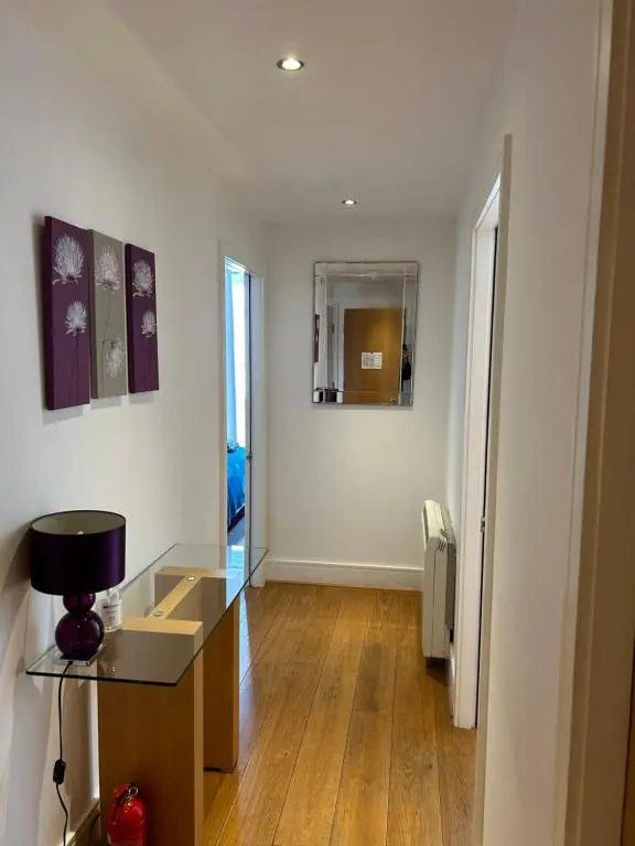 a living room with a glass table and a mirror at 1 Bedroom Castleview Apartment 404-Free Parking in Inverness