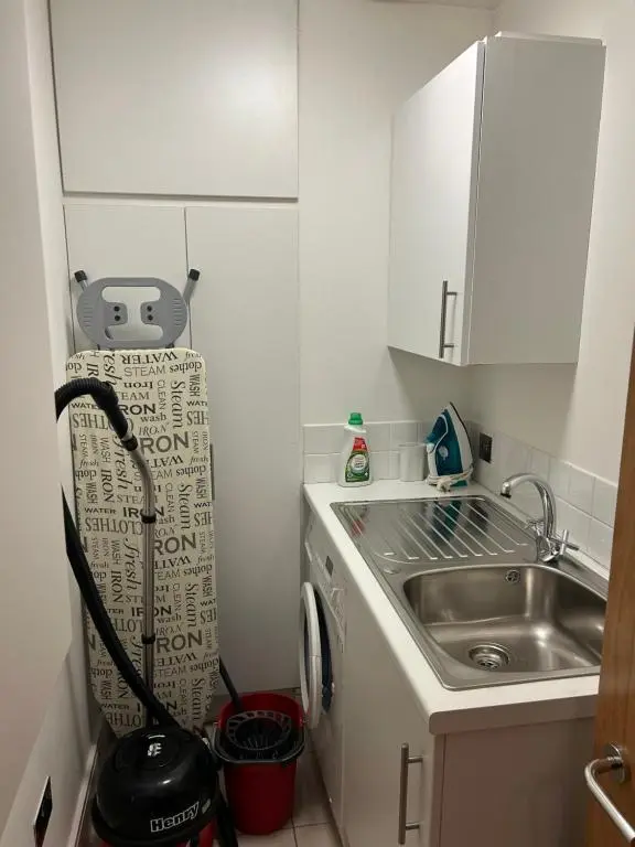 a small kitchen with a sink and a washing machine at 1 Bedroom Castleview Apartment 404-Free Parking in Inverness