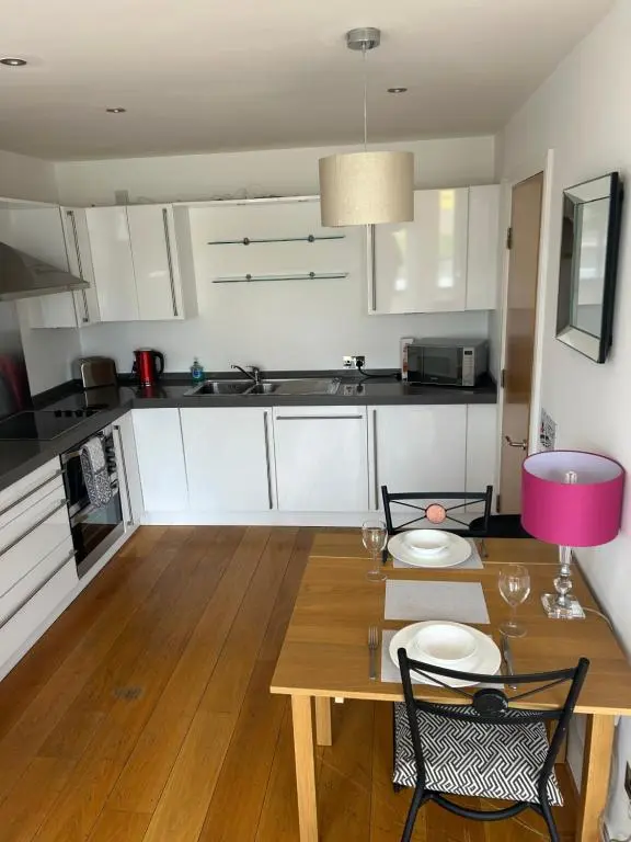 a kitchen with a wooden table with two chairs and a dining room at 1 Bedroom Castleview Apartment 404-Free Parking in Inverness