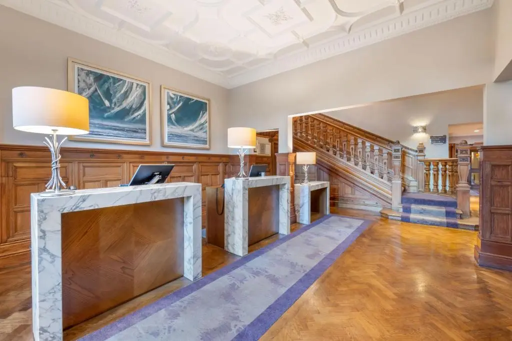 a living room with wood paneling and a staircase at The Lodges at Craigendarroch Country Club in Ballater
