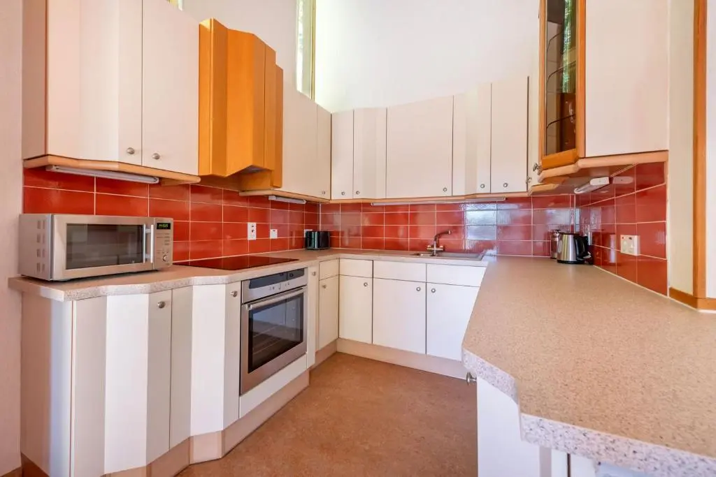 a kitchen with white cabinets and a microwave at The Lodges at Craigendarroch Country Club in Ballater