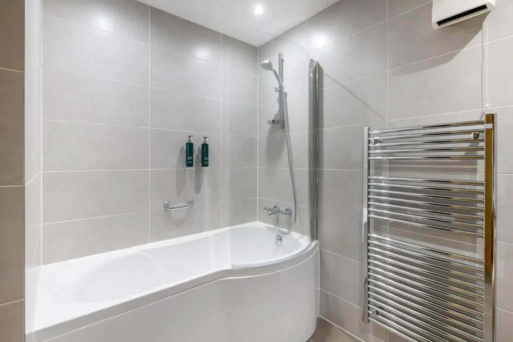 a white bathroom with a tub and a shower at The Lodges at Craigendarroch Country Club in Ballater