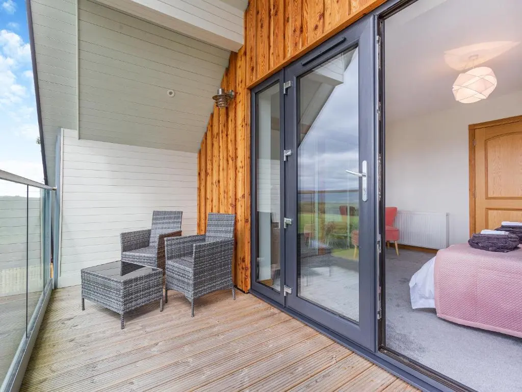 a room with sliding glass doors and a bedroom at The Larches - Uk46804 in Culbokie