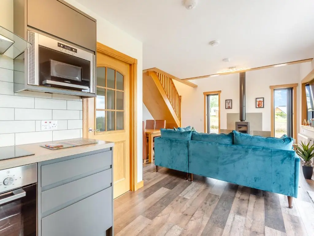 a kitchen with a blue couch in a room at The Larches - Uk46804 in Culbokie